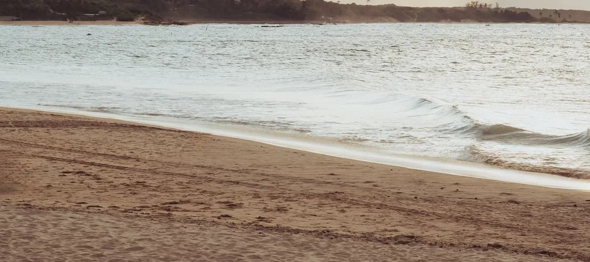 The same beach at sunset, completely empty: no people and no boats